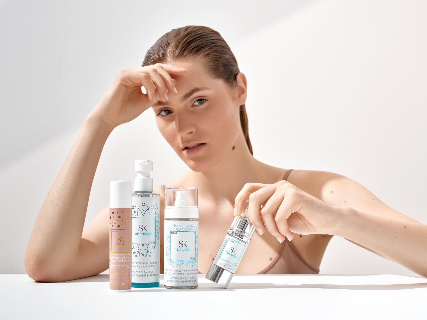 Skintegra Solar I, Amphibian, Nectar i Tria Light sa ženom koja je uz proizvode