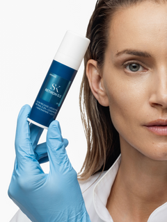 Žena sa bočicom Skintegra Retiron 0.2 limposomalnog retinala 0.2%